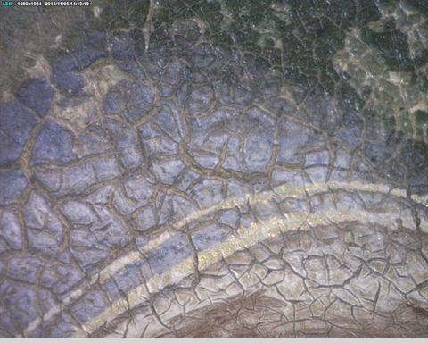 Painting. Detail view of a cracked painted surface with two bands glimmering faintly with gold against delphinium blue.
